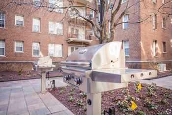A modern sculpture in a courtyard with a brick building in the background.